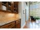 Butler's pantry featuring granite countertops and custom cabinetry at 652 Pathview Ct, Dacula, GA 30019
