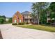 Attractive brick home with a long driveway, a well-maintained lawn, featuring a stone facade and mature tree at 652 Pathview Ct, Dacula, GA 30019