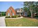 Attractive brick home with a well-maintained lawn, featuring a stone facade and mature tree at 652 Pathview Ct, Dacula, GA 30019