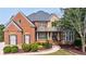 Charming brick and stone home featuring manicured lawn, professional landscaping and shuttered windows at 652 Pathview Ct, Dacula, GA 30019