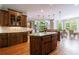 Spacious kitchen with hardwood floors, granite countertops, a kitchen island, and a sunlit dining area at 652 Pathview Ct, Dacula, GA 30019