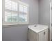 Bright laundry room featuring a utility sink, white cabinets, and window with plantation shutters at 652 Pathview Ct, Dacula, GA 30019