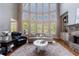 Bright living room with tall windows, stone fireplace, and comfortable seating at 652 Pathview Ct, Dacula, GA 30019