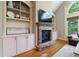 Bright living room featuring built-in shelving, a stone fireplace, and a large arched window at 652 Pathview Ct, Dacula, GA 30019