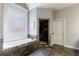 Main bathroom featuring a jacuzzi tub, walk-in shower, and travertine floors at 652 Pathview Ct, Dacula, GA 30019