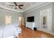 A spacious main bedroom with hardwood floors, trey ceiling, and an exterior door to the backyard at 652 Pathview Ct, Dacula, GA 30019