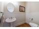 Charming powder room features a pedestal sink, paneled walls, and hardwood floors at 652 Pathview Ct, Dacula, GA 30019