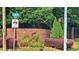 Street view of Lenox road sign, brick wall with dark metallic sign, and lush bushes at 3275 Lenox Ne Rd # 110, Atlanta, GA 30324
