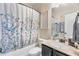 Well-lit bathroom features a shower-tub combo and black vanity with neutral countertop at 466 Sweet Apple Ln, Buford, GA 30518