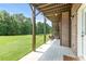 Spacious covered patio with brick accents and outdoor seating overlooking lush green lawn at 466 Sweet Apple Ln, Buford, GA 30518