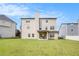 Spacious backyard shows a two-story home with a covered patio, surrounded by lush green grass under a blue sky at 4854 Cathedral Ct, Powder Springs, GA 30127