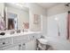 Bathroom with a white vanity, framed mirror, toilet, and tub with shower, all complemented by light-colored walls at 4854 Cathedral Ct, Powder Springs, GA 30127