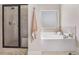 Bathroom with a glass-enclosed shower, a soaking tub, and a window with lots of natural light at 4854 Cathedral Ct, Powder Springs, GA 30127