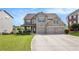 Stately brick home with a three-car garage, manicured lawn, and inviting curb appeal at 4854 Cathedral Ct, Powder Springs, GA 30127