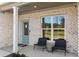 Inviting front porch with chairs, a blue door, a welcome mat, and white brick exterior walls at 5430 Hyde Rd, Cumming, GA 30040