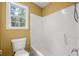 Bathroom with a bathtub/shower combo, window for natural light, and toilet at 125 Ancient Oak Ln, Stockbridge, GA 30281