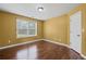 Bedroom featuring hardwood floors, a large window, and white painted door at 125 Ancient Oak Ln, Stockbridge, GA 30281