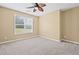 Neutral bedroom featuring a window with blinds, neutral carpet, and a ceiling fan at 125 Ancient Oak Ln, Stockbridge, GA 30281