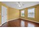 Bedroom features include hardwood floors, yellow walls, a ceiling fan, and windows offering natural light at 125 Ancient Oak Ln, Stockbridge, GA 30281
