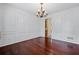 Formal dining room with rich wood floors, classic chandelier, and wainscoting details at 125 Ancient Oak Ln, Stockbridge, GA 30281