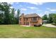 Brick home featuring a well-manicured lawn, a patio, and mature trees surrounding the property at 125 Ancient Oak Ln, Stockbridge, GA 30281
