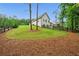 View of the expansive backyard with a black wooden fence and manicured landscaping at 131 Forsyth Park Ln, Woodstock, GA 30188