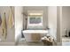 Bright bathroom featuring a freestanding tub with marble surround and elegant decor at 131 Forsyth Park Ln, Woodstock, GA 30188
