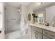 Bathroom with glass shower door, a grey vanity, and elegant gold fixtures at 131 Forsyth Park Ln, Woodstock, GA 30188