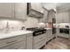 Gourmet kitchen showcasing gray cabinets, gas range, and stone backsplash for a modern and functional cooking area at 131 Forsyth Park Ln, Woodstock, GA 30188