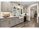 Bright kitchen featuring gray cabinets, farmhouse sink, and modern countertops, creating a stylish culinary space at 131 Forsyth Park Ln, Woodstock, GA 30188