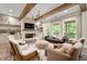 Cozy living room with stone fireplace, beamed ceilings, and natural light, creating a warm and inviting atmosphere at 131 Forsyth Park Ln, Woodstock, GA 30188