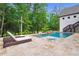 Private in-ground pool and hot tub with stone tile deck and lush green surroundings at 131 Forsyth Park Ln, Woodstock, GA 30188