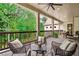 Covered porch featuring wood flooring, ceiling fan, comfortable seating, and backyard views at 131 Forsyth Park Ln, Woodstock, GA 30188
