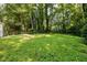 Expansive backyard featuring lush greenery and mature trees, offering privacy and a serene outdoor space at 1744 Blossom Ln, Austell, GA 30168