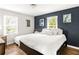 Comfortable bedroom with dark blue accent wall and an abundance of natural light from the windows at 1744 Blossom Ln, Austell, GA 30168