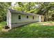 Side exterior view of the house, showcasing vinyl siding, foundation, and backyard at 1744 Blossom Ln, Austell, GA 30168