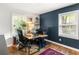 A contemporary office space features dark blue walls, two windows, and hardwood floors at 1744 Blossom Ln, Austell, GA 30168