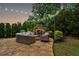 Backyard fireplace feature and lounge seating beautifully illuminated with string lights at 2579 Lulworth Ln, Marietta, GA 30062
