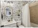 Bathroom features fun dog-themed wallpaper, a shower-tub, and a round mirror at 2579 Lulworth Ln, Marietta, GA 30062