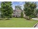 Charming two-story brick home with a well-manicured lawn, mature trees, and lovely landscaping at 2579 Lulworth Ln, Marietta, GA 30062