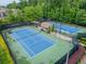 Overhead view of two well-maintained tennis courts with lights and a covered seating area at 2579 Lulworth Ln, Marietta, GA 30062