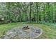 Private backyard with a stone fire pit and small storage shed at 2816 Highland Park Dr, Stone Mountain, GA 30087