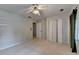 Neutral bedroom featuring a ceiling fan, window, built-in shelves and neutral carpet at 2816 Highland Park Dr, Stone Mountain, GA 30087