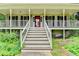 Inviting front porch with white railings, steps leading up to the entrance, and charming outdoor lighting at 2816 Highland Park Dr, Stone Mountain, GA 30087