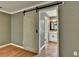 Main bedroom with hardwood floors and sliding barn door to bathroom at 2816 Highland Park Dr, Stone Mountain, GA 30087
