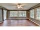 Enclosed sunroom with a ceiling fan and multiple windows at 2816 Highland Park Dr, Stone Mountain, GA 30087