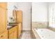Bathroom features a soaking tub with stone surround, vanity and wood cabinets at 2735 Jims Ne Rd, Marietta, GA 30066