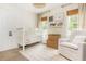 Adorable Bedroom with a white crib, cozy rocking chair, and natural window coverings at 2735 Jims Ne Rd, Marietta, GA 30066