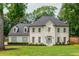 Elegant white brick home featuring a well-manicured lawn and charming blue shutters nestled among mature trees at 2735 Jims Ne Rd, Marietta, GA 30066