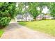 Long driveway leading to a beautiful two-story home with white brick, shutters, and well-manicured front yard at 2735 Jims Ne Rd, Marietta, GA 30066